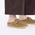 Zuecos Birkenstock Buckley Oiled Leather Cognac, calzado por modelo femenino primer plano de los pies
