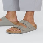 Sandalias Birkenstock Arizona Birko-Flor Saffiano Stone Coin, calzado por modelo masculino, primer plano del pie