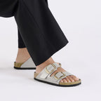 Sandalias Birkenstock Arizona Big Buckle Natural Leather Stone Coin, calzado por modelo femenino, primer plano del tobillo