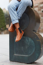 Helsinki Cognac Brown, en uso, modelo sentado sobre escultura