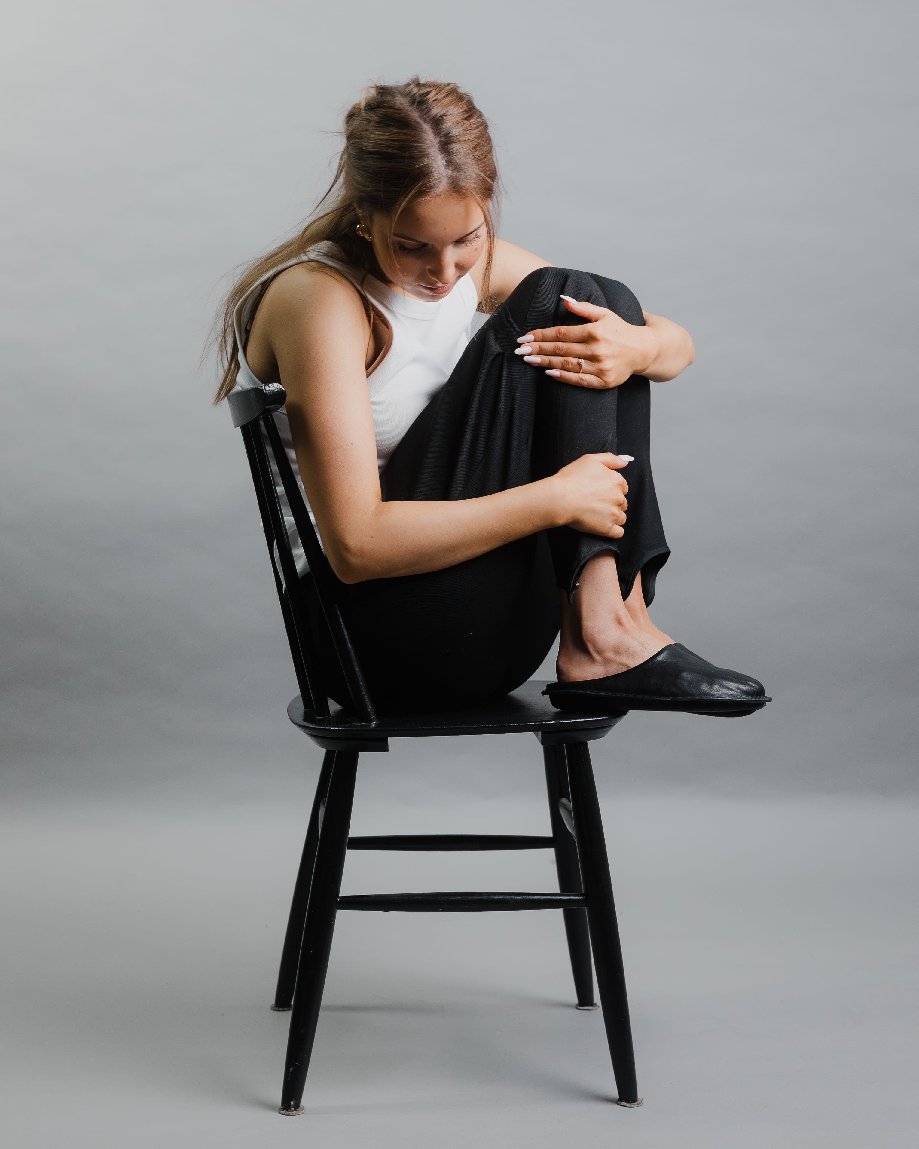 Zuecos VIBAe Roma Preto Black, calzado por modelo femenino, sentada, cuerpo entero