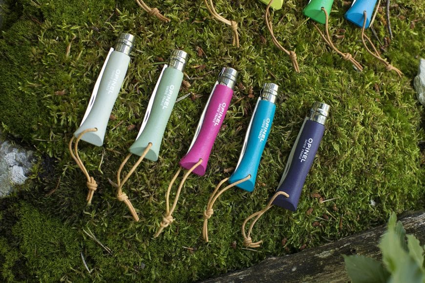 Cuchillo Opinel Trekking N°06 Morado - vista 4, varios cuchillos sobre musgo, estilo de vida