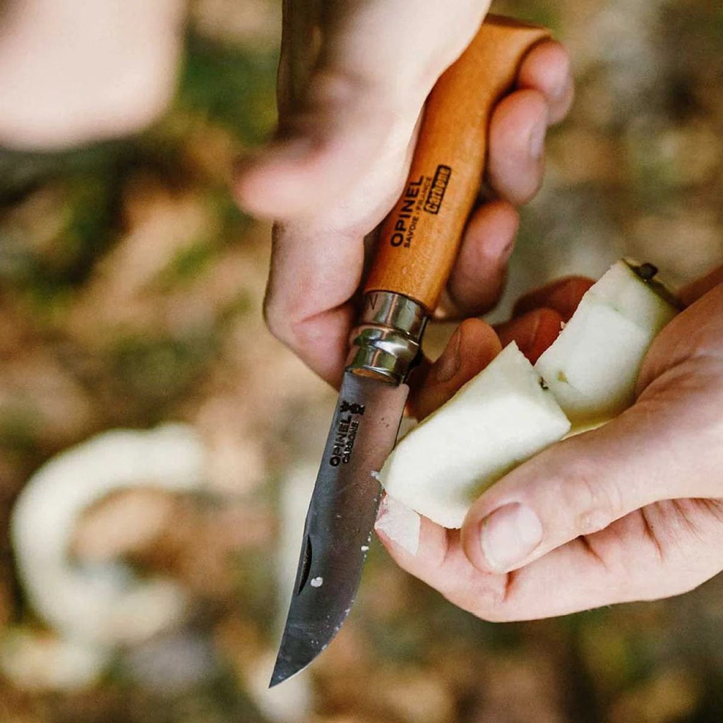 Cuchillo Opinel N°7 Carbon Steel - vista 2, en uso, pelando una fruta