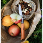 Cuchillo Opinel N°9 Carbon Steel - vista 2, en uso, cortando una manzana