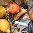 Cuchillo Opinel N°10 Carbon Steel - vista 3, en uso, junto a frutas y frutos secos