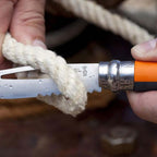 Cuchillo Opinel N°08 Outdoor Naranjo - vista 2, en uso, cortando una cuerda