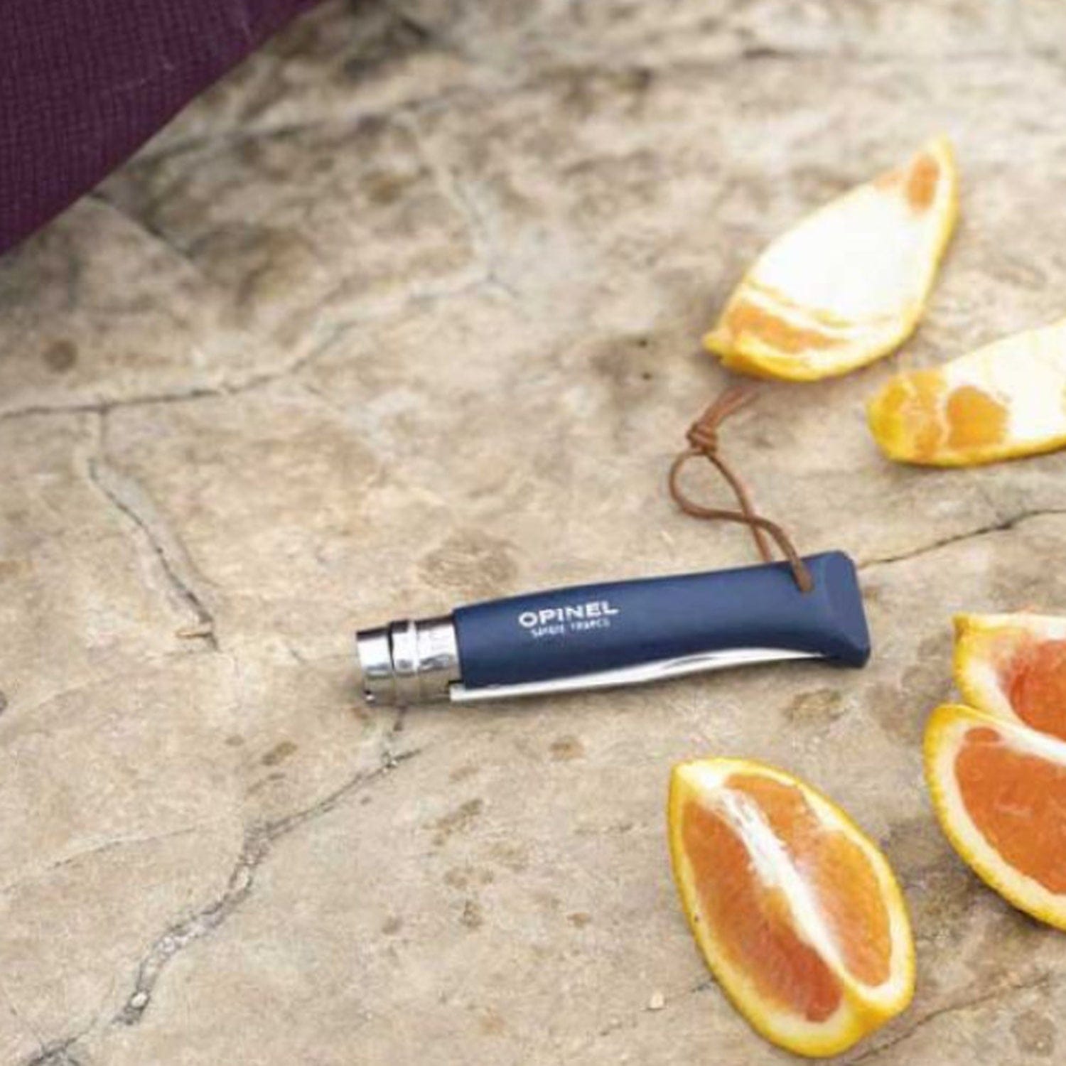 Cuchillo Opinel Trekking N°8 Azul - vista 6, cuchillo abierto en uso, con naranjas, estilo de vida