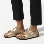 Sandalias Birkenstock Arizona Gold, calzado por modelo femenino, primer plano de los pies