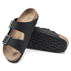 Sandalias Birkenstock Arizona Black Vegan, par completo en tres cuartos, con la suela a la vista