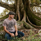 Gorro Conner Hats Swansey Weathered Cotton Newsboy Cap, puesto por modelo masculino, sentado al aire libre