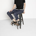 Sandalias Birkenstock Arizona Big Buckle Black, calzado por modelo femenino sentada, primer plano