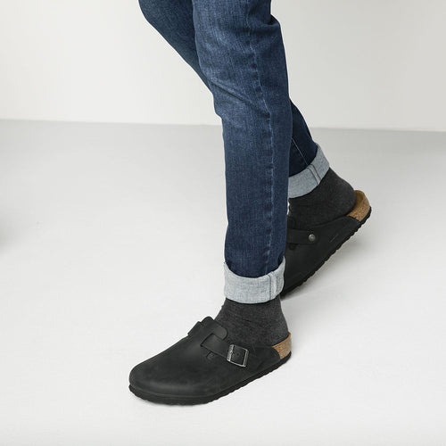 Zuecos Birkenstock Boston Oiled Black, calzado por modelo masculino, primer plano del tobillo