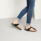 Sandalias Birkenstock Gizeh Patent Black, calzado por modelo femenino, cuerpo entero, en movimiento