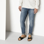 Sandalias Birkenstock Madrid Black, calzado por modelo masculino, primer plano de piernas y pies