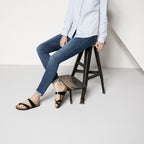 Sandalias Birkenstock Mayari Black Lack, calzado por modelo femenino sentada, primer plano
