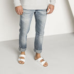 Sandalias Birkenstock Arizona White, calzado por modelo masculino, primer plano de piernas y pies